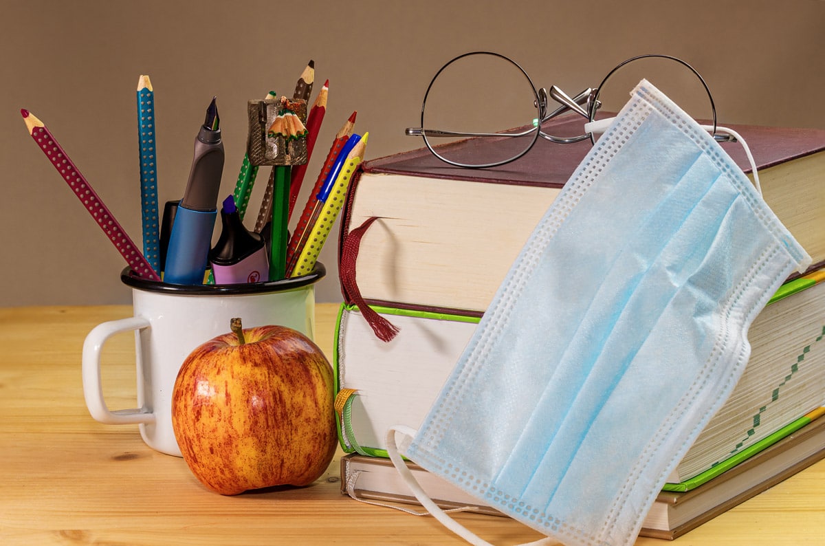 books, apples, pencil and mask